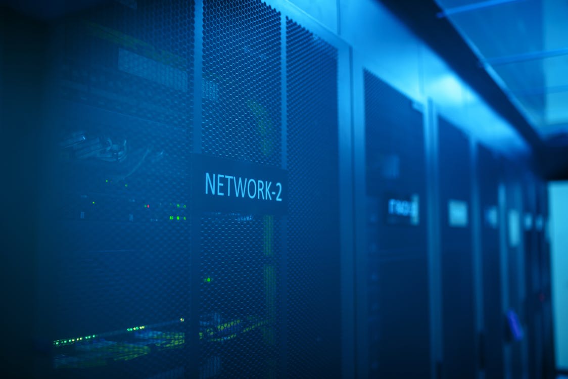 Serverraum mit blau beleuchteten Netzwerk-Racks, Symbol für KI-Rechenkapazität